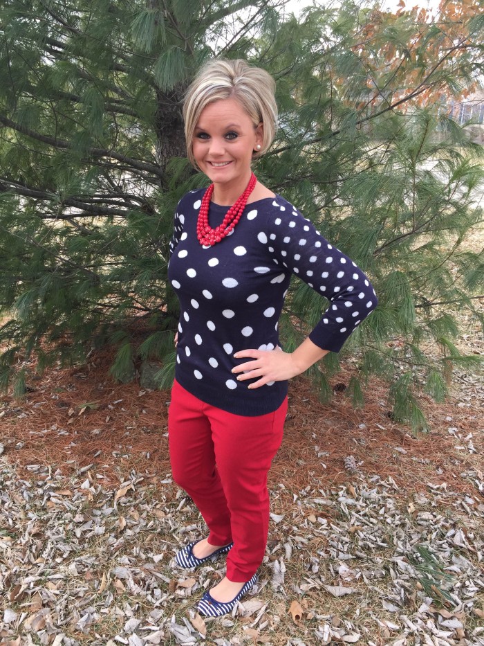 Navy polka dot sweater outfit with red jeans red necklace.