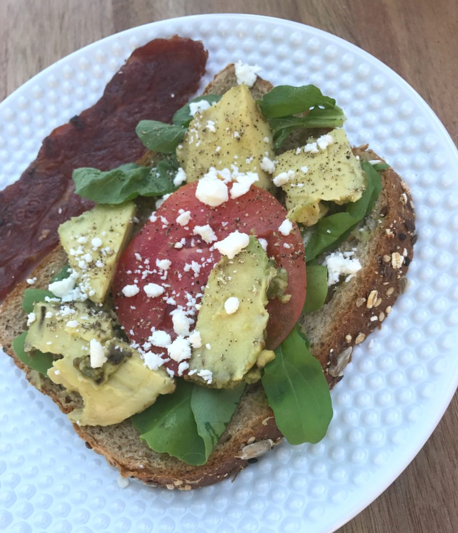 Avacodo tomato toast with spinach turkey bacon and goat cheese