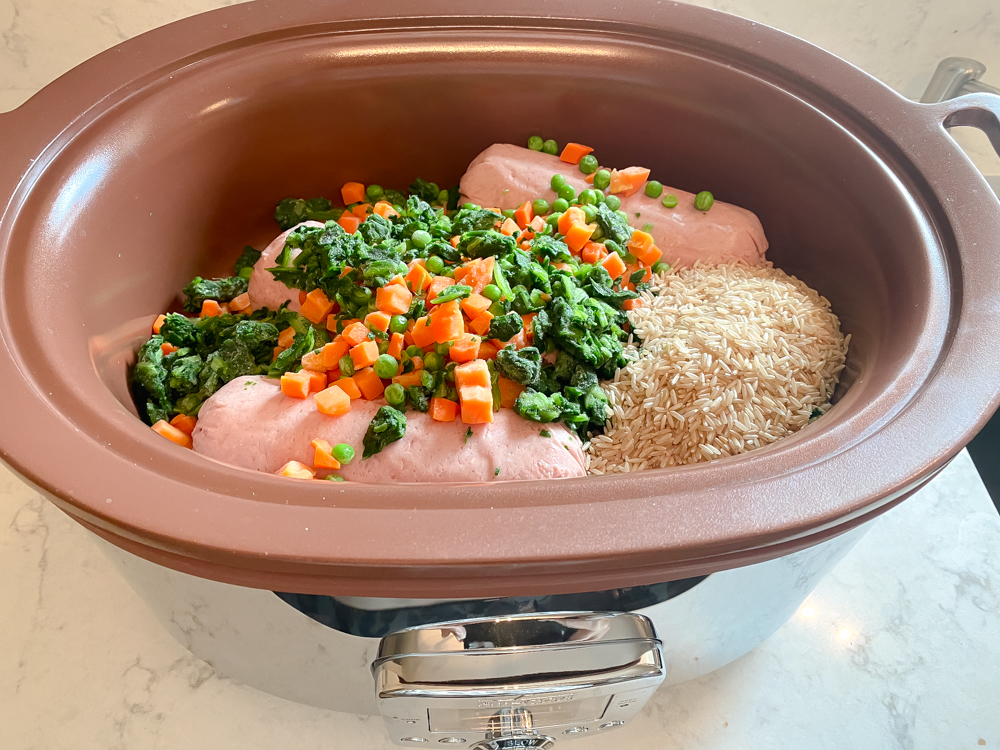 Homemade dog food in crockpot with frozen vegetables, ground turkey and rice.